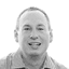 Smiling man in a collared shirt looking directly at the camera in black and white.