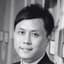 Headshot of a smiling Asian man in a suit looking directly at the camera.
