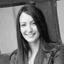 Black and white portrait of a smiling woman with long dark hair looking forward.